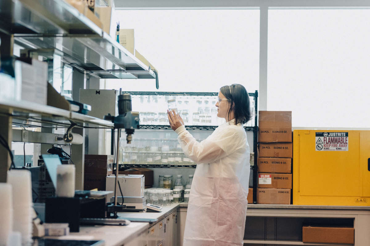 Emma Klingman in a Lab Holding a Jar